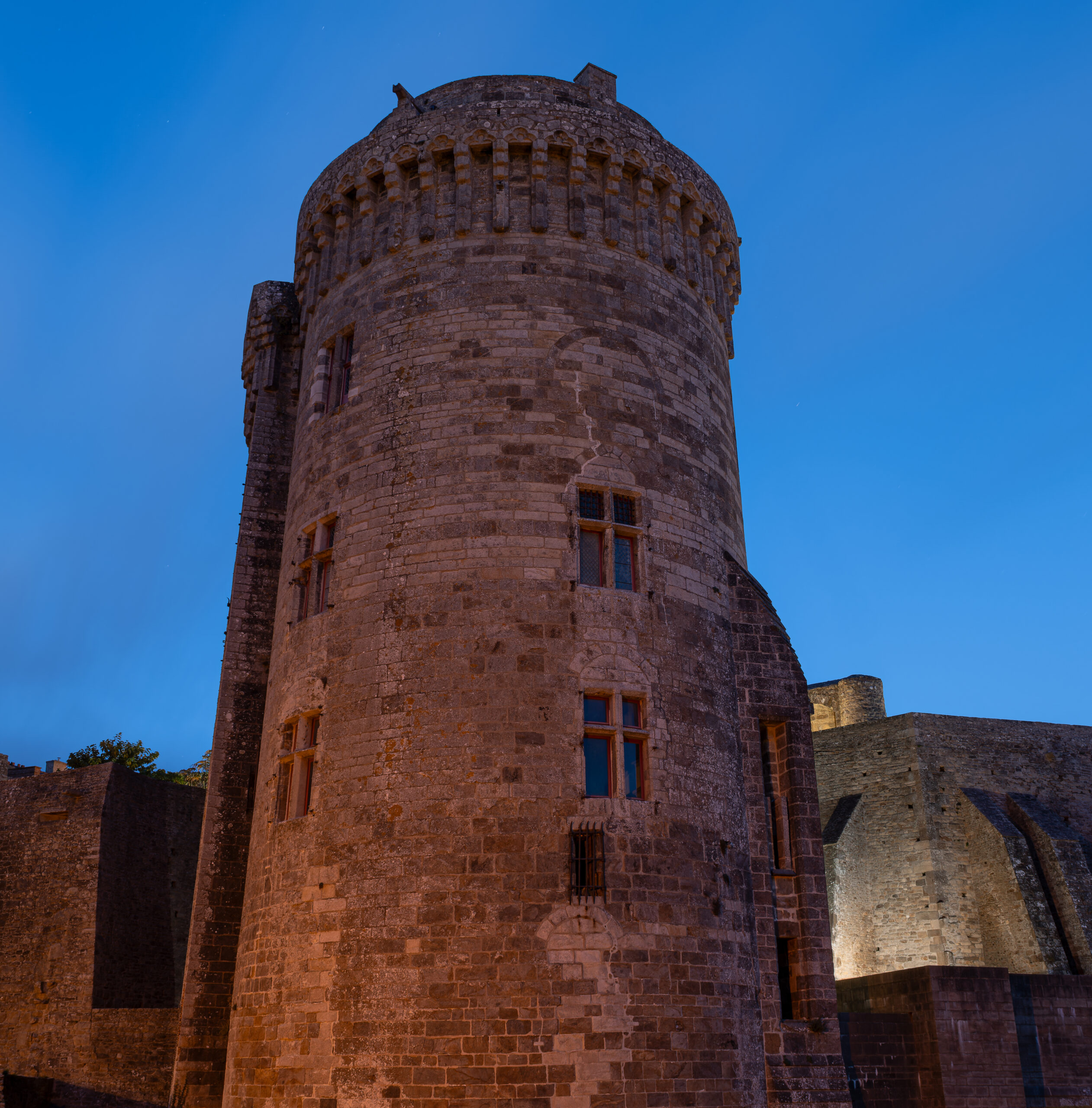 La tour du château de Dinan éclairée à la tombée du jour.